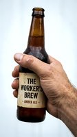 Male hand holding amber ale beer bottle with label against white background, ready for beverage advertising and promotional use.