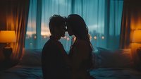 Romantic silhouette of young couple sharing intimate moment in dimly lit bedroom with city lights and turquoise curtains creating moody atmospheric backdrop for love stories.