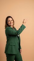 Professional businesswoman in green suit pointing and presenting with confident smile on neutral background for corporate marketing materials.