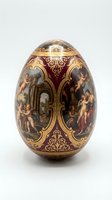 Ornate porcelain egg with baroque paintings and gold filigree on burgundy background, classical European decorative art collectible for luxury interior design.