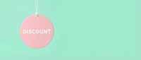 Pink round discount tag hanging on mint green background with copy space for retail sale promotion and shopping concepts.
