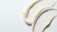 Creamy beige foundation or concealer makeup smears on white background showing smooth texture and blendable coverage for cosmetic beauty applications.