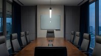 Modern corporate boardroom with wooden conference table and executive chairs for business meetings and presentations.