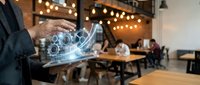 Professional businessman using holographic growth chart technology in modern cafe workspace for business analytics and data visualization.