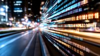 Digital data stream visualization with light trails and binary code pattern against blurred urban night background showing technology convergence and data flow.