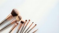 Professional makeup brushes with rose gold handles arranged on white background for beauty and cosmetics applications.