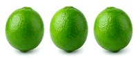 Three fresh green limes with textured skin isolated on white background, suitable for food, beverage, culinary, and healthy lifestyle content.
