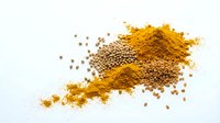 Golden turmeric powder and coriander seeds scattered on white background for cooking and spice blend recipes.