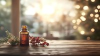 Brown glass bottle with winter berries and pine branches on wooden surface against blurred bokeh lights and window background, creating cozy atmosphere.