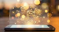 Digital email marketing concept with glowing envelope icons floating above smartphone screen in warm bokeh background for business communication.