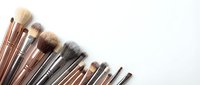 Collection of professional makeup brushes arranged in a row on white background with copy space for beauty and cosmetic design.