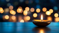 Traditional oil lamp with glowing flame on blue surface against warm bokeh lights background creating peaceful ambiance for meditation and relaxation.