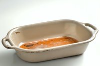 Homemade tomato soup in vintage white ceramic baking dish with handles on light background, comfort food photography for recipe blogs and cookbooks.