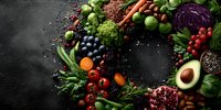 Colorful wreath made of fresh vegetables, fruits, berries, and nuts on dark background. Healthy eating concept for food photography.