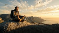 Young Caucasian male hiker with backpack sitting on mountain summit at golden hour sunset, enjoying panoramic valley view with flying birds overhead.