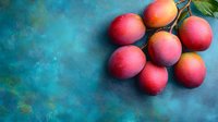 Fresh ripe plums arranged on rustic blue textured surface with natural lighting for healthy eating and organic fruit concepts.