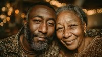 Loving African American senior couple embracing warmly with golden bokeh lights creating romantic atmosphere for holiday celebrations and family moments.