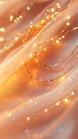 Glowing golden bokeh lights on soft peach fabric with delicate beaded chains creating magical festive atmosphere for celebrations and special occasions.
