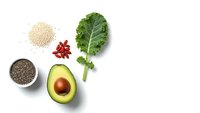 Fresh avocado half with kale leaf, quinoa, chia seeds and goji berries arranged on white background for healthy eating and superfood nutrition concepts.