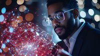 Young African American businessman with glasses examining glowing digital network visualization against blurred bokeh lights in dark setting.