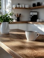 White coffee cup on wooden kitchen counter with morning sunlight casting shadows, fresh flowers in vase, minimalist scandinavian interior design background.