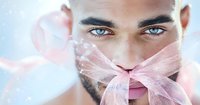 Close up portrait of young middle eastern man with striking blue eyes and pink sheer ribbon covering mouth against light background. Artistic fashion concept.