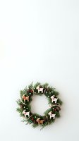 Festive evergreen wreath adorned with gingerbread ornaments, candy canes, and pinecones on white background, ready for holiday design projects and seasonal marketing materials.