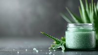 Green smoothie with spirulina powder and fresh herbs in glass jar on dark background with water drops and plant leaves, healthy detox drink.