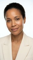Professional African American businesswoman in beige blazer smiling confidently on white background for corporate headshot and business marketing materials.