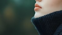 Close-up profile view of Asian woman's face showing pink lips and black knitted turtleneck sweater against blurred green background, soft natural lighting.