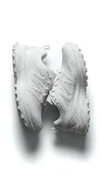 Pair of all-white chunky trail running sneakers with aggressive rubber soles, isolated on white background for footwear fashion and sport design use.