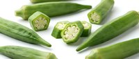 Fresh green okra pods whole and sliced showing seeds on white background. Healthy organic vegetable for cooking and nutrition isolated for design use.