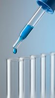 Laboratory pipette dropping blue liquid into test tubes for scientific research and chemical analysis experiments in modern lab setting.