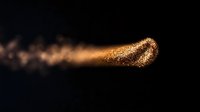 Magical golden glitter trail with sparkling particles flowing on black background, creating ethereal light effect for luxury design and festive backgrounds.