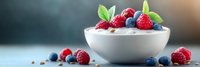 Fresh mixed berries with mint leaves in white bowl, healthy breakfast yogurt parfait with strawberries and blueberries for organic food photography.