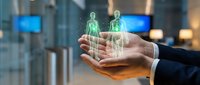 Businessman hands holding holographic human figures in modern office environment representing digital transformation and human resources technology.