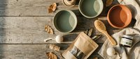 Cozy autumn flat lay with ceramic bowls, wooden spoons, walnuts and coffee beans on rustic wooden background for seasonal kitchen styling.