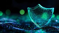 Glowing turquoise shield symbol with sparkles on dark background, digital security concept visualization. Protection and cybersecurity metaphor.
