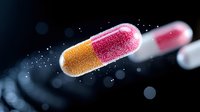 Glowing pharmaceutical capsule with gold and pink powder floating in dark space with bokeh effect, medical and healthcare concept for drug development.