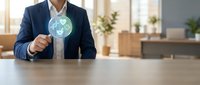 Professional businessman in dark suit holding glowing digital globe with recycling symbols in modern office environment for sustainability presentations.