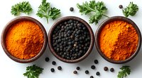 Aromatic spices in wooden bowls - turmeric powder and black peppercorns garnished with fresh parsley leaves on white background, culinary composition.
