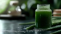 Fresh green smoothie in glass jar with chia seeds on dark surface, healthy detox drink for wellness lifestyle and nutrition concept.