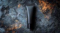Black cosmetic tube on dark textured background with golden accents. Minimalist premium skincare product photography for beauty and cosmetic industry marketing.