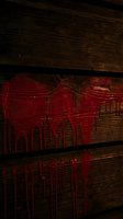 Red paint dripping down dark wooden planks creating dramatic horror atmosphere for Halloween decorations and spooky themed projects.