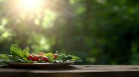 Fresh organic cherry tomatoes and green herbs on rustic wooden table with sunlit forest background, perfect for healthy eating concepts.