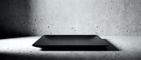 Empty black rectangular platform or podium on concrete floor with textured gray wall background, suitable for product display, mockups, and commercial presentations.