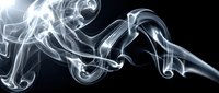 Elegant white smoke swirls flowing gracefully against a dark black background, creating abstract curling shapes with soft light and shadow contrast.