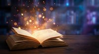 Open book with magical glowing light and bokeh effects on wooden surface creating enchanting reading atmosphere for education and storytelling concepts.