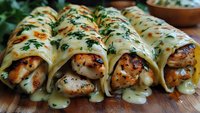 Grilled chicken wrapped in creamy herb sauce on wooden board. Savory rolled poultry with fresh herbs and melted cheese topping for gourmet cooking recipes.