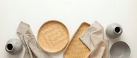 Eco-friendly bamboo kitchen utensils and natural linen textiles arranged on neutral background for sustainable cooking and dining lifestyle.